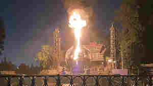 A fire-breathing dragon bursts into flames during a popular Disneyland show