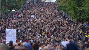 Tens of thousands march against Serbia's populist leadership following mass shootings