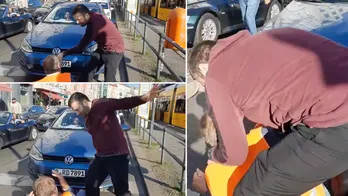 German driver erupts in anger as he slaps and grabs radical climate protester blocking road in Berlin