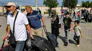 Foreign nationals and the injured gather at Gaza's border on reports of gate opening