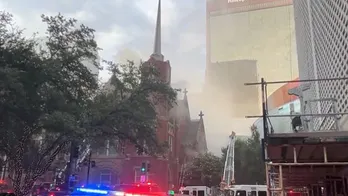 Smoke rises above the historic First Baptist Church in downtown Dallas